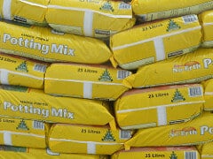 Potting Mixes Heap of yellow-bagged potting mix.